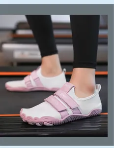 Primer plano de calzado minimalista blanco con correas de velcro sobre una cinta de correr