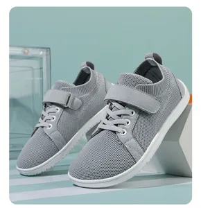 Detailed side view of grey kids barefoot sneaker with mesh upper and velcro strap
