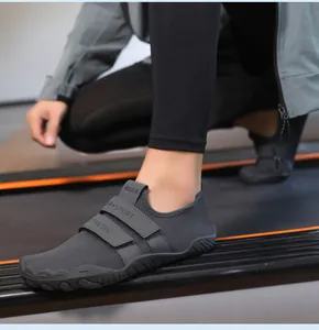 Detalle de zapato deportivo gris oscuro con correas de velcro para fitness interior