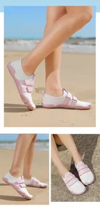 Detalle de zapatos acuáticos rosa y blanco con suela antideslizante en la playa de arena