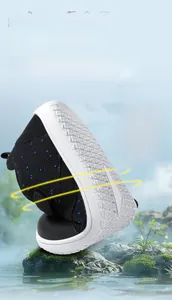 Macro view of flexible black knit toddler shoe with white sole bending without deformation
