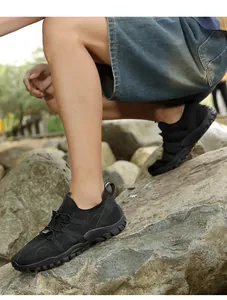 Detalle de zapatos de agua negros con malla transpirable y suela antideslizante en rocas