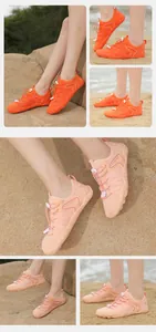 Dettaglio scarpe da scoglio traspiranti arancioni e rosa su spiaggia e rocce