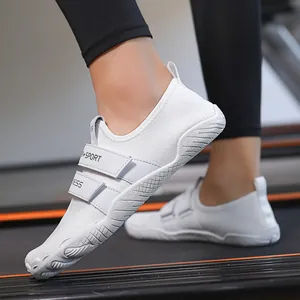 Zapatillas deportivas blancas minimalistas con velcro sobre una cinta de correr en gimnasio