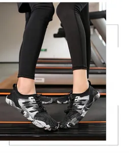 Detalle de zapatos de agua camo gris con suela de goma blanca en cinta de correr