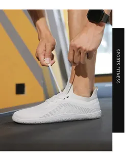 Detail of white wide-toe barefoot sneakers with breathable knit mesh on a treadmill
