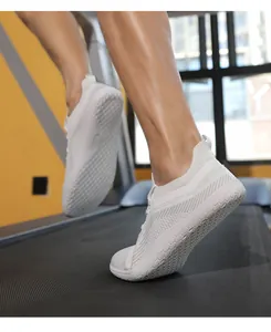 Detail of white breathable mesh sneakers featuring hexagonal anti-slip sole on a treadmill