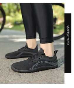 Outdoor shot of breathable black knit athletic shoes with non-slip soles on a model