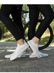 Outdoor shot of breathable white knit sneakers with textured soles for casual walking