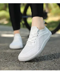 Close-up of white breathable knit walking shoes with laces on a model outdoors