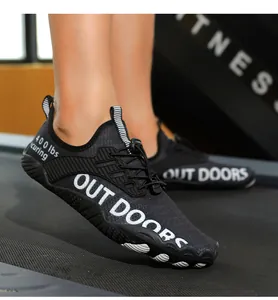 Details von Outdoor-Watschuhen mit rutschfesten Sohlen und 'OUT DOORS'-Aufdruck am Laufband