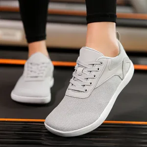 Grey barefoot walking shoes with breathable mesh and wide toe box on treadmill