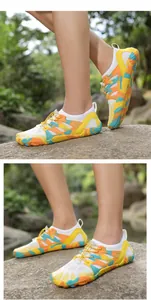 Detalle de zapatillas de agua camuflaje con cordones elásticos sobre rocas