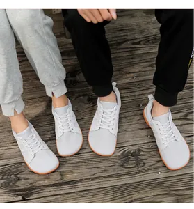Vue de dessus de baskets pieds nus minimalistes en maille grise sur un pont en bois