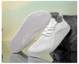 Detailed view of breathable knit upper and honeycomb non-slip rubber sole on white sneakers
