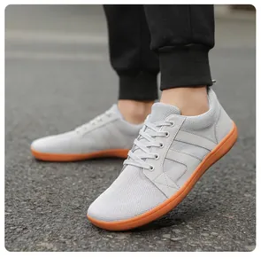 Vue détaillée de chaussures minimalistes en mesh gris avec semelle en caoutchouc orange