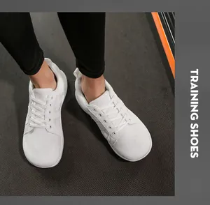 Vue de dessus de chaussures d'entraînement en maille blanche avec bout large sur tapis