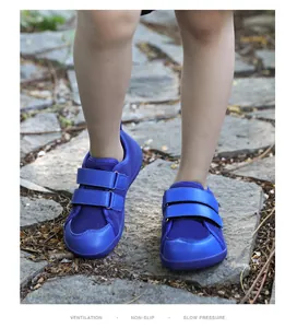 Blue kids barefoot trail shoes with dual hook-and-loop straps on a stony path walk