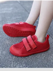Detailed side view of kids barefoot shoes with breathable red mesh and non-slip wavy soles