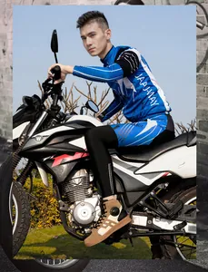 Close-up of rider wearing protective blue and white motorcycle gear on a bike
