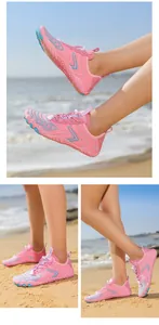 Scarpe acquatiche ad asciugatura rapida rosa e blu per spiaggia mostrate sulla sabbia