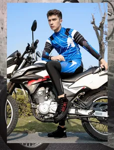 Full-body shot of a male rider in a blue and black motorcycle suit on a racing bike