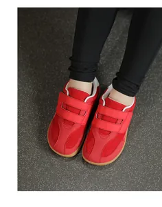 Detail of red barefoot kids' shoes with mesh upper and double hook-and-loop strap
