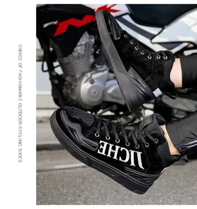 Detail of high-top black motorcycle boots with IICHE white embroidery on a rider