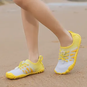 Leichte gelb-graue Kinder-Wasserschuhe mit schnelltrocknendem Mesh am Sandstrand
