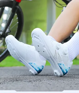 Close-up of professional white cycling shoes with dual rotary dials and blue wave detail