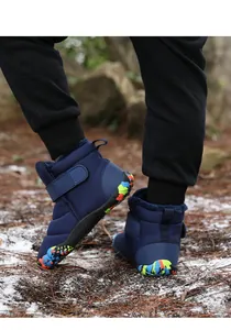 Detail of blue winter boot showing warm fleece lining and colorful graffiti rubber sole