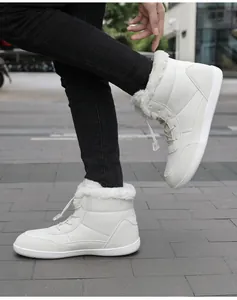 Detail of white high-top snow boots with thick faux fur lining and bungee lace-up closure