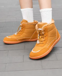 Close-up of ginger yellow winter boots with thick faux fur lining and drawstring toggles