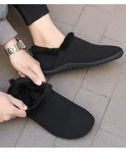 Detail of warm black knit slippers with thick faux fur lining and anti-slip rubber sole