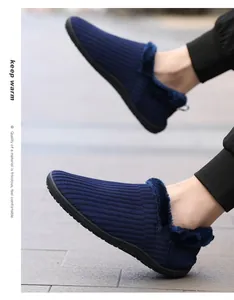 Detail of warm navy blue knitted slippers with thick plush lining on tiled floor