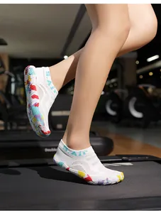 Dettaglio scarpa acquatica in rete bianca con suola in gomma con graffiti colorati