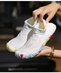 Dettaglio scarpe da scoglio bianche in maglia con suola in gomma mimetica multicolore