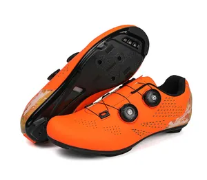 Macro view of bright orange cycling shoes featuring dual dial closure and breathable holes