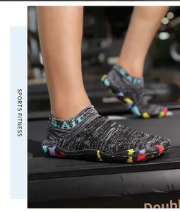 Dettaglio di scarpe a piedi nudi in maglia con suola graffiti colorata su tapis roulant