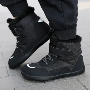 Winter kids black snow boots with warm fur lining and reflective details on tile floor