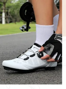 Dettaglio scarpa da ciclismo bianca con chiusura a rotella e strisce riflettenti