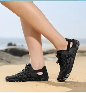 Nahaufnahme schwarzer schnelltrocknender Wasserschuhe mit rutschfester Sohle am Strand