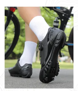 Dettaglio scarpe MTB nere con chiusura a rotore e tacchetti della suola antiscivolo
