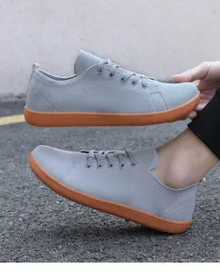 Macro view of grey knit breathable barefoot shoes featuring a flexible orange rubber sole