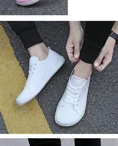 Top view of white breathable mesh barefoot sneakers on asphalt road with yellow lines
