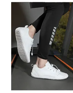 Close-up of white barefoot wide toe shoes on a treadmill with non-slip rubber soles