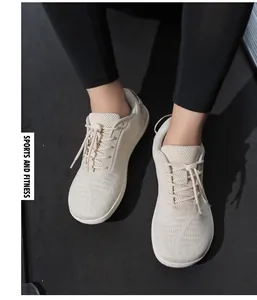 On-foot view of beige mesh barefoot shoes on a fitness mat for sports and gym wear