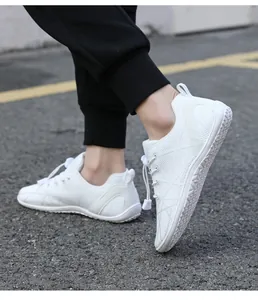 Detailed close-up of white barefoot shoes showing anti-slip sole on asphalt road
