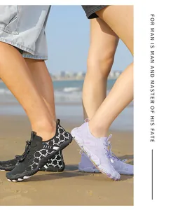 Détail d'un couple portant des chaussures de plage à motif nid d'abeille sur le sable