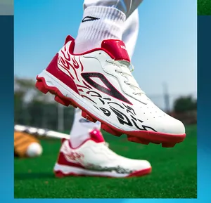 Detail of red and white professional soccer shoes with turf studs on grass pitch